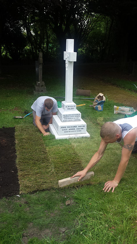Our stone masons can be seen here laying the new turf to the grave area and checking the level of the ground surrounding the grave.